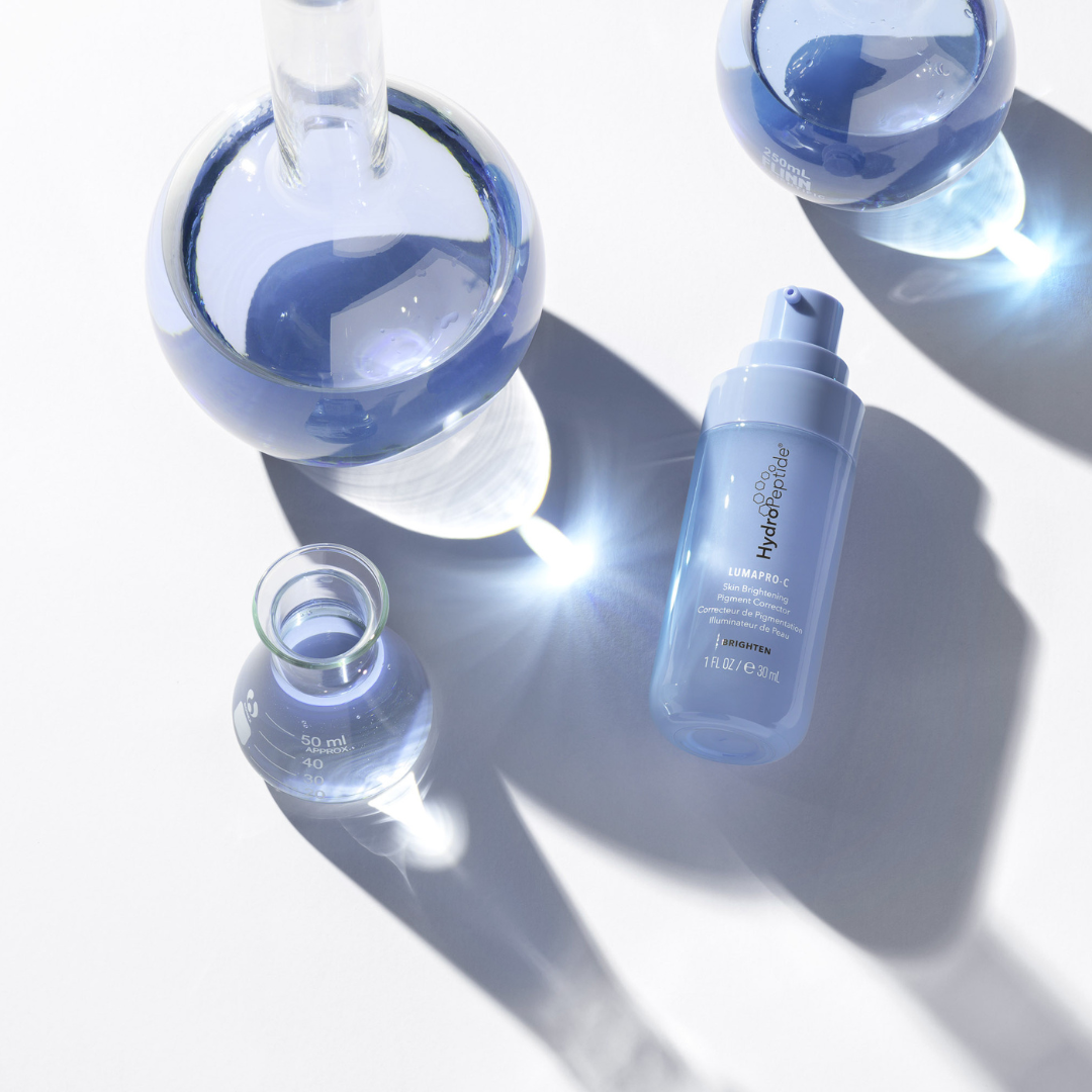 Cosmetic bottles with blue liquid on a light background