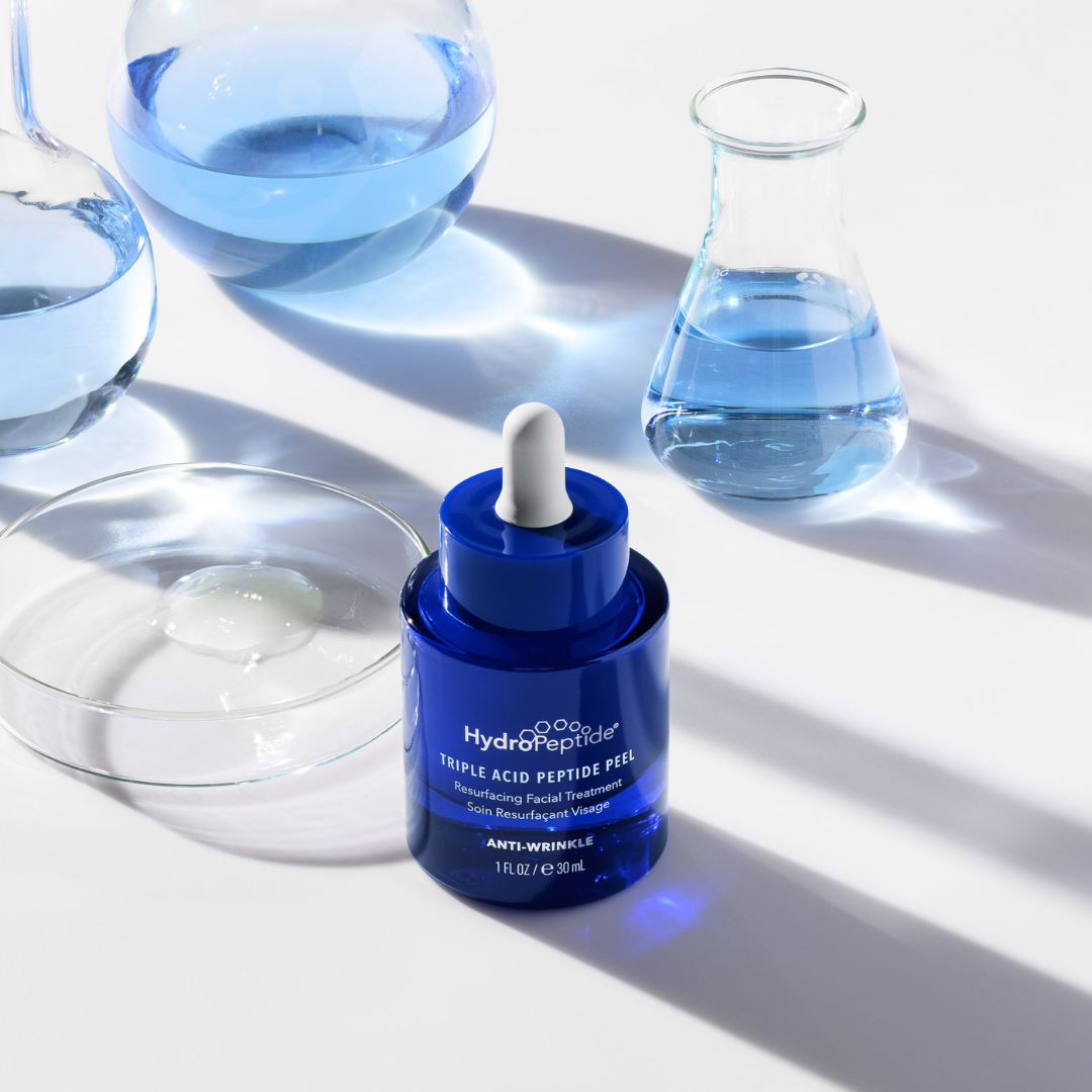 Blue skincare serum bottle with dropper on a white background