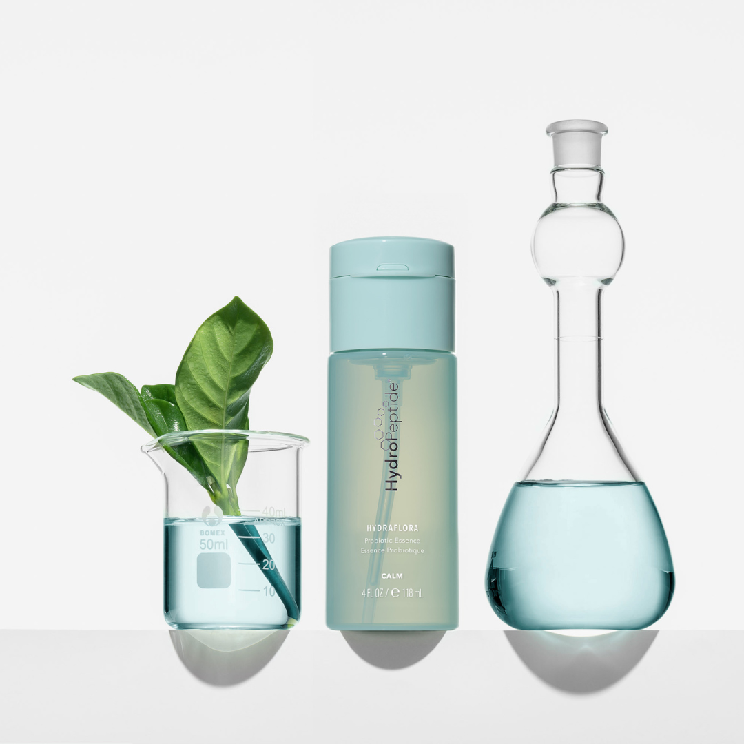 Hydraflora with blue liquid and a plant on a white background