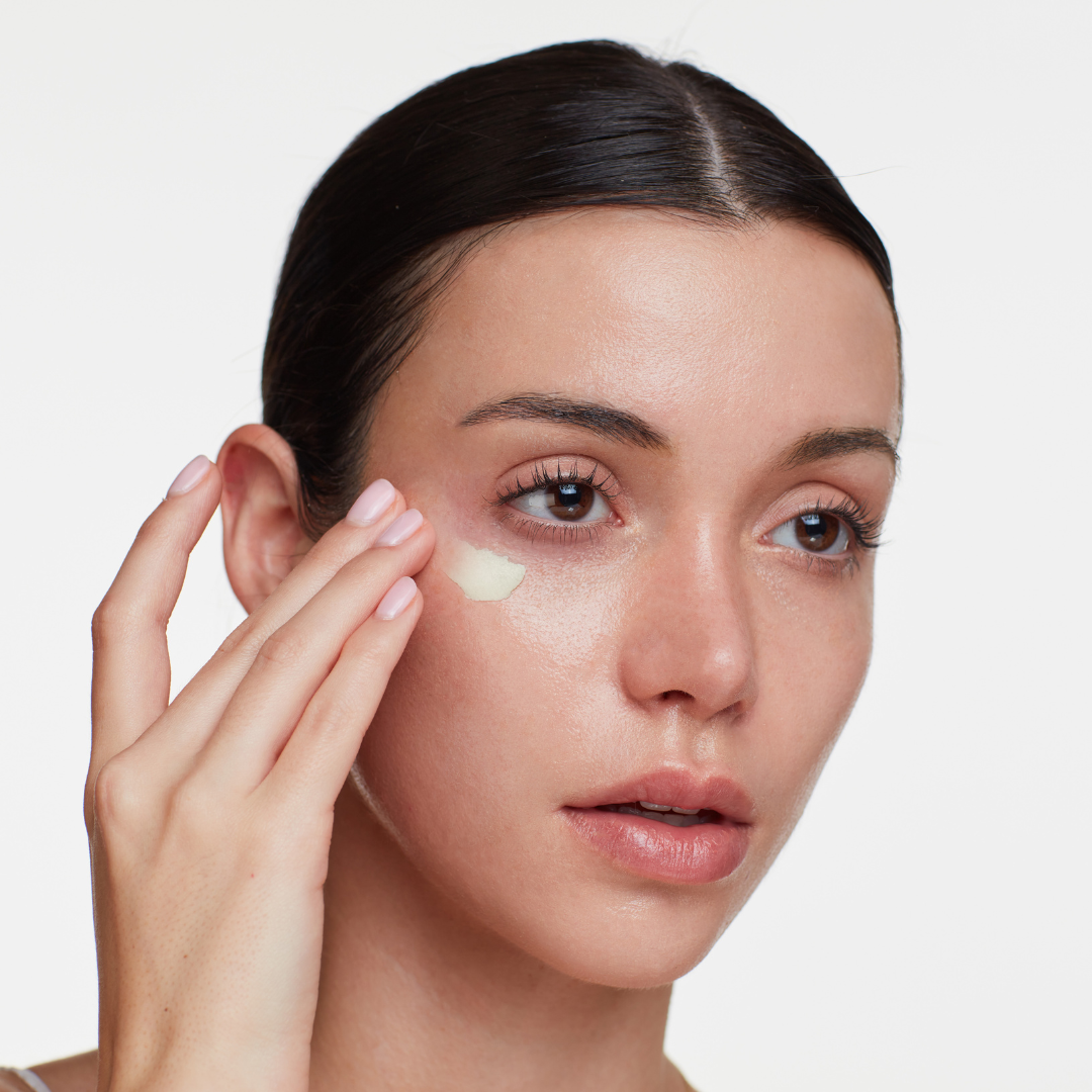 Woman applying Makeup Melt to her face with a neutral background