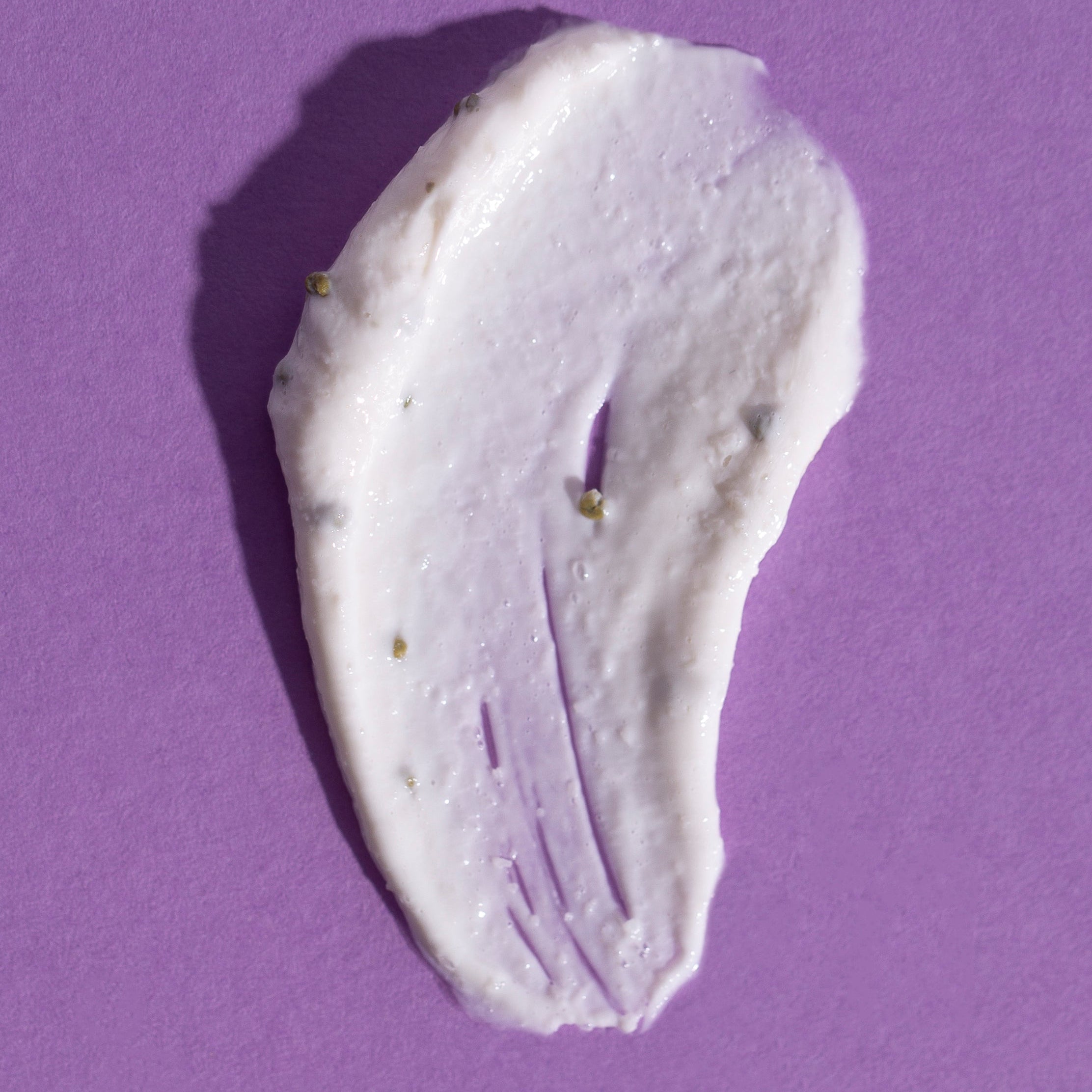 White cream smear on a purple background