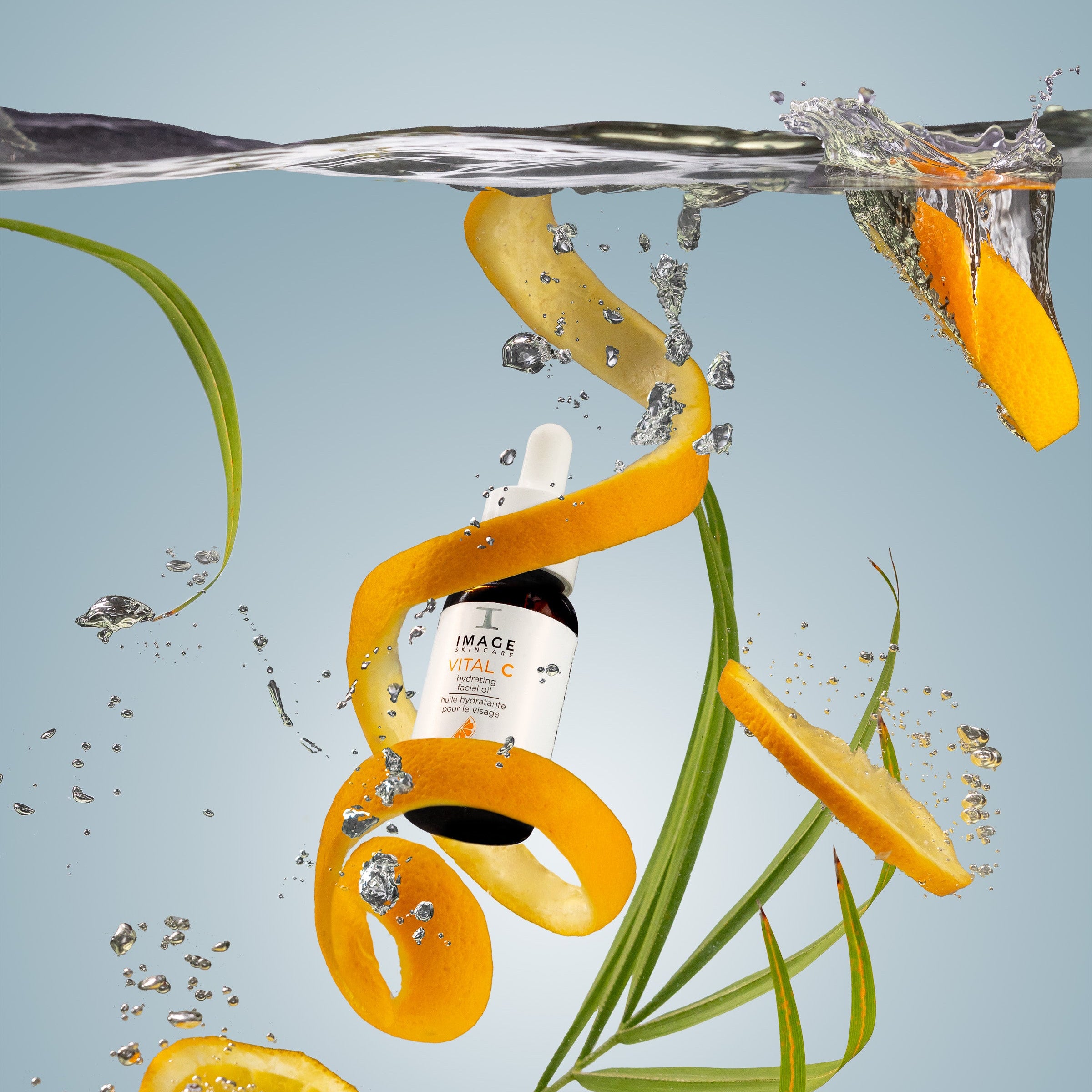 Bottle of Skinfood Mise en Scene with orange slices and leaves underwater on a light blue background