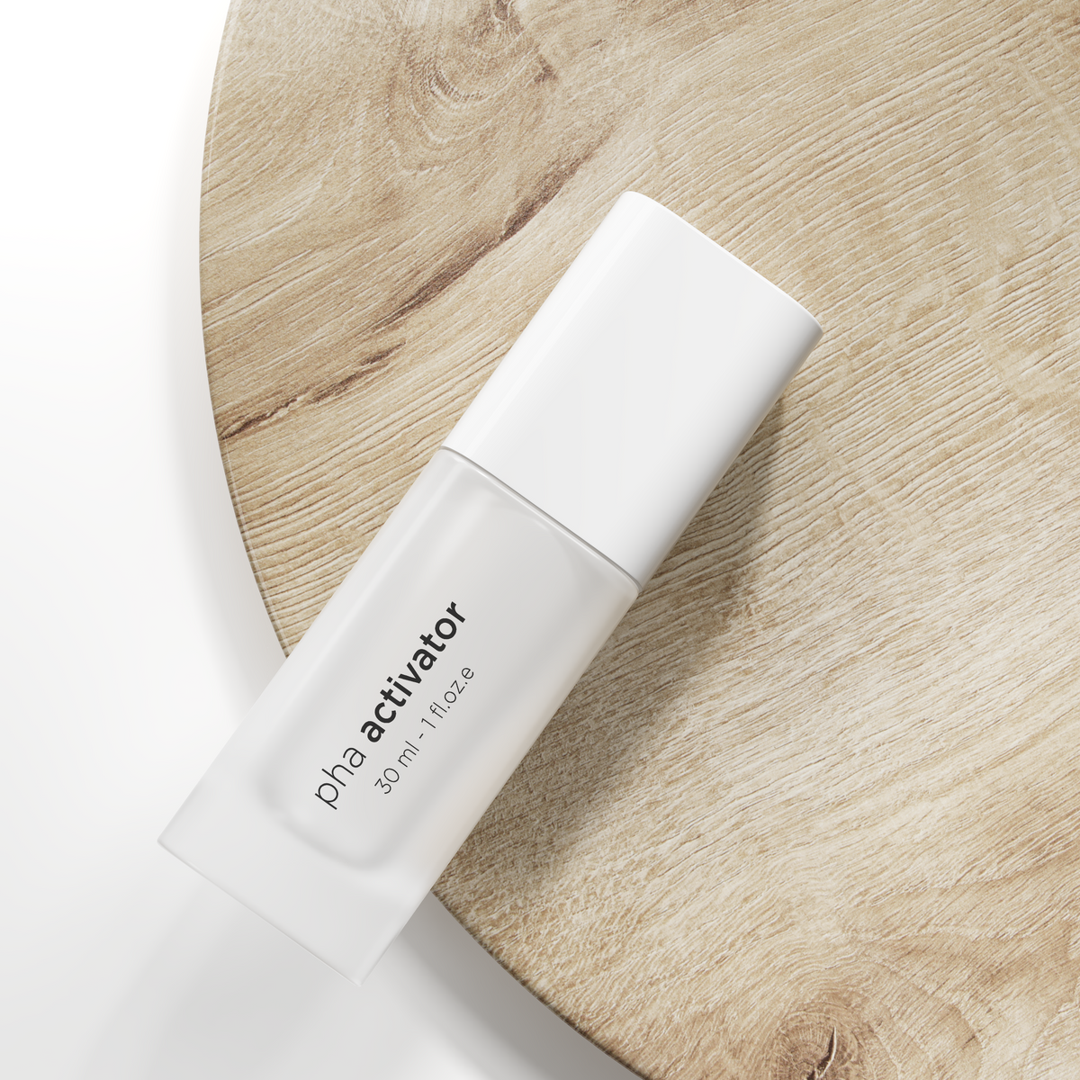 A 30 ml bottle of pha activator skincare product, shown diagonally on a light wood slice prop against a clean white background.