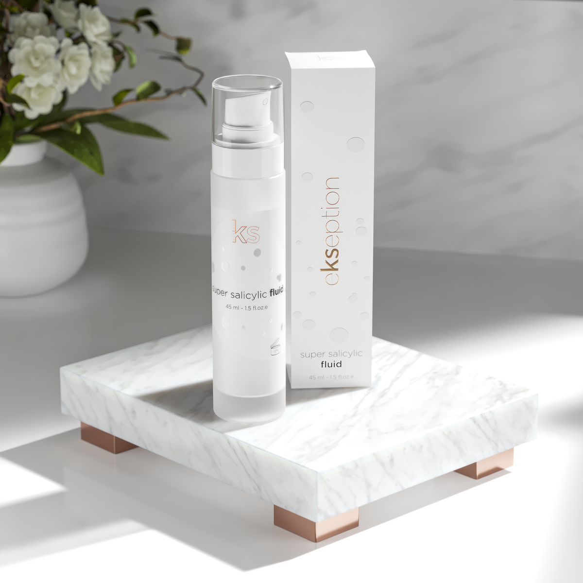 A skincare bottle labeled 'ekseption super salicylic fluid' stands beside its matching white box on a white marble tray with rose-gold legs, set against a soft gray marble background with white flowers in a vase.