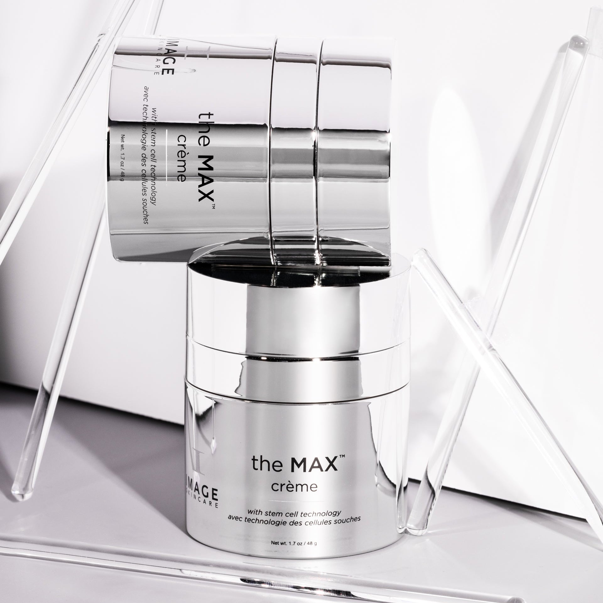 Two silver skincare containers labeled 'the MAX crème' on a white background