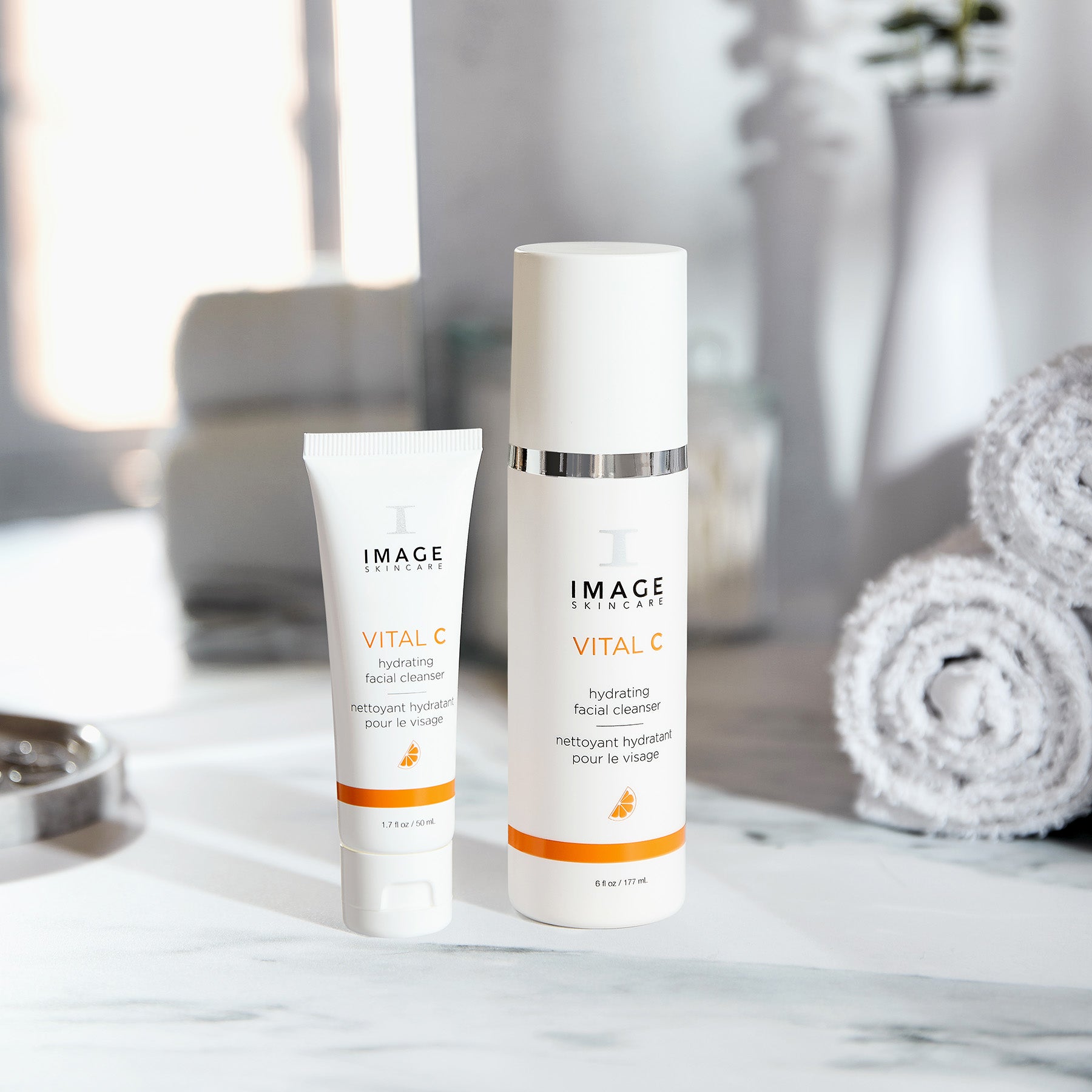 Two bottles of IMAGE Skincare products on a marble surface with a blurred background