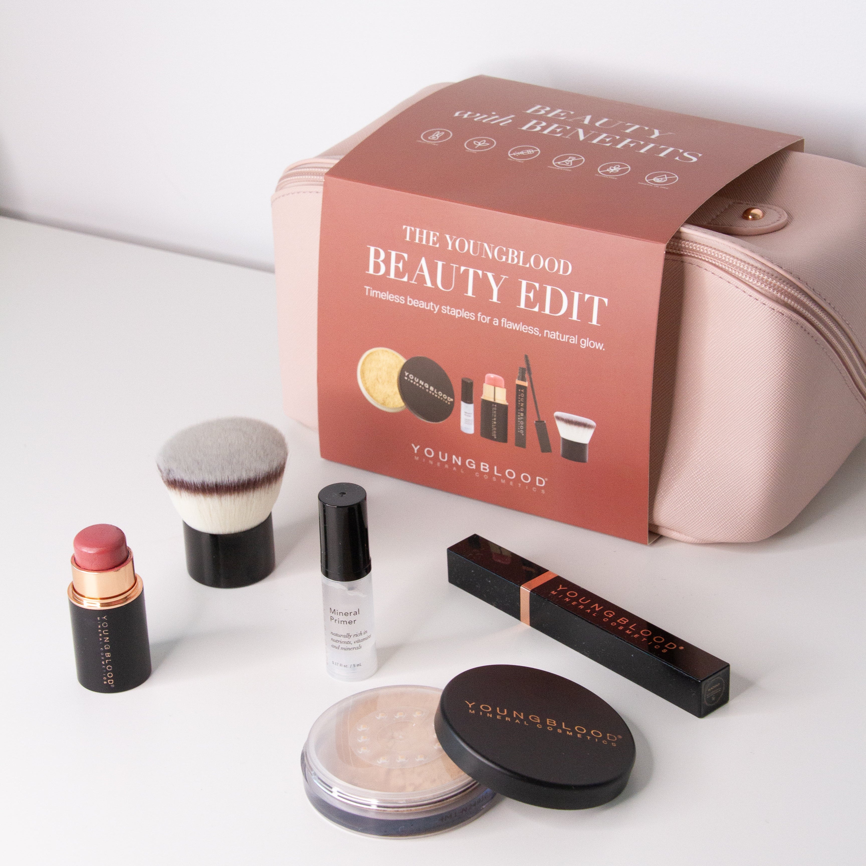 Makeup products and packaging on a white surface with 'The Youngblood Beauty Edit' box.