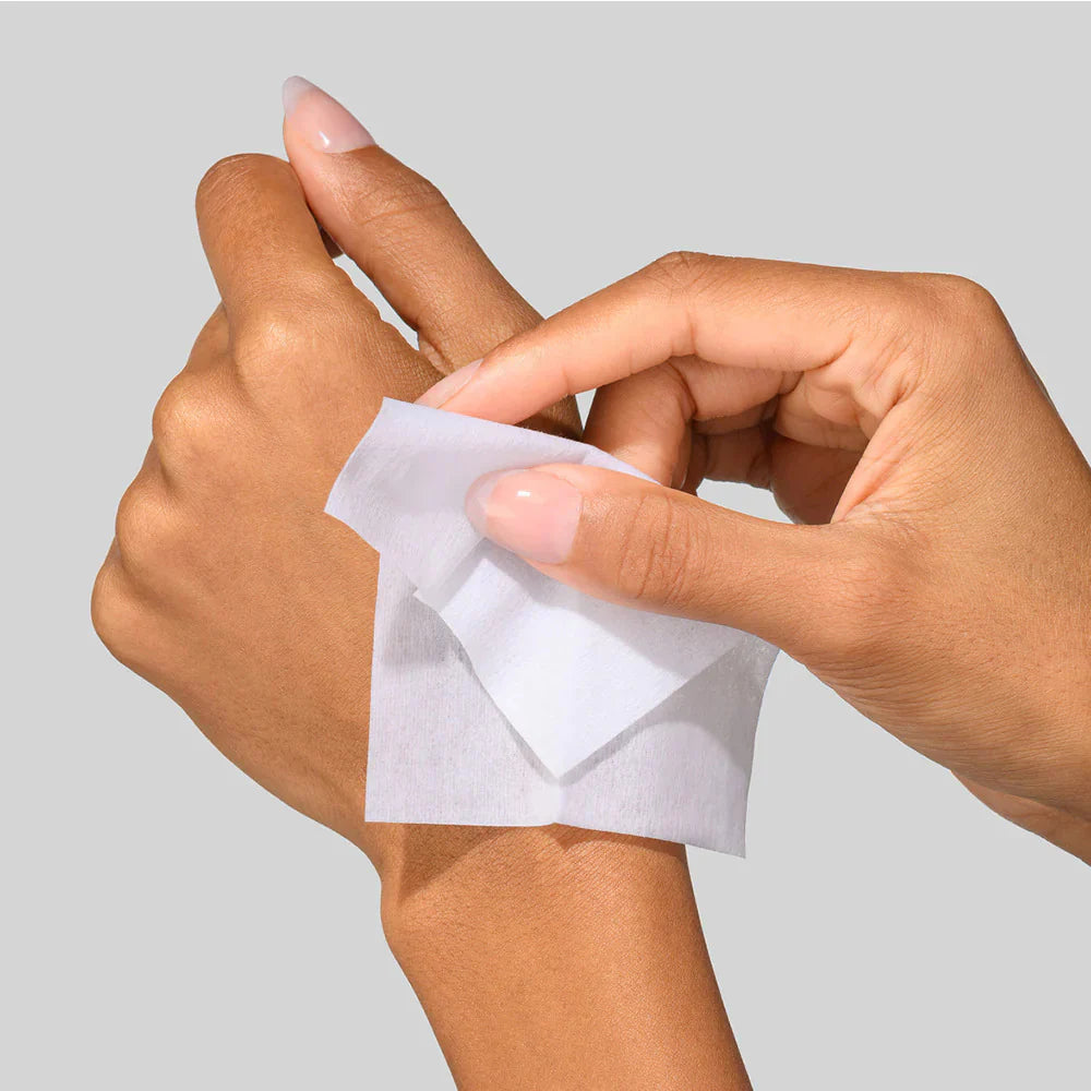 Person applying a 5x Power Peel pad to their wrist against a gray background