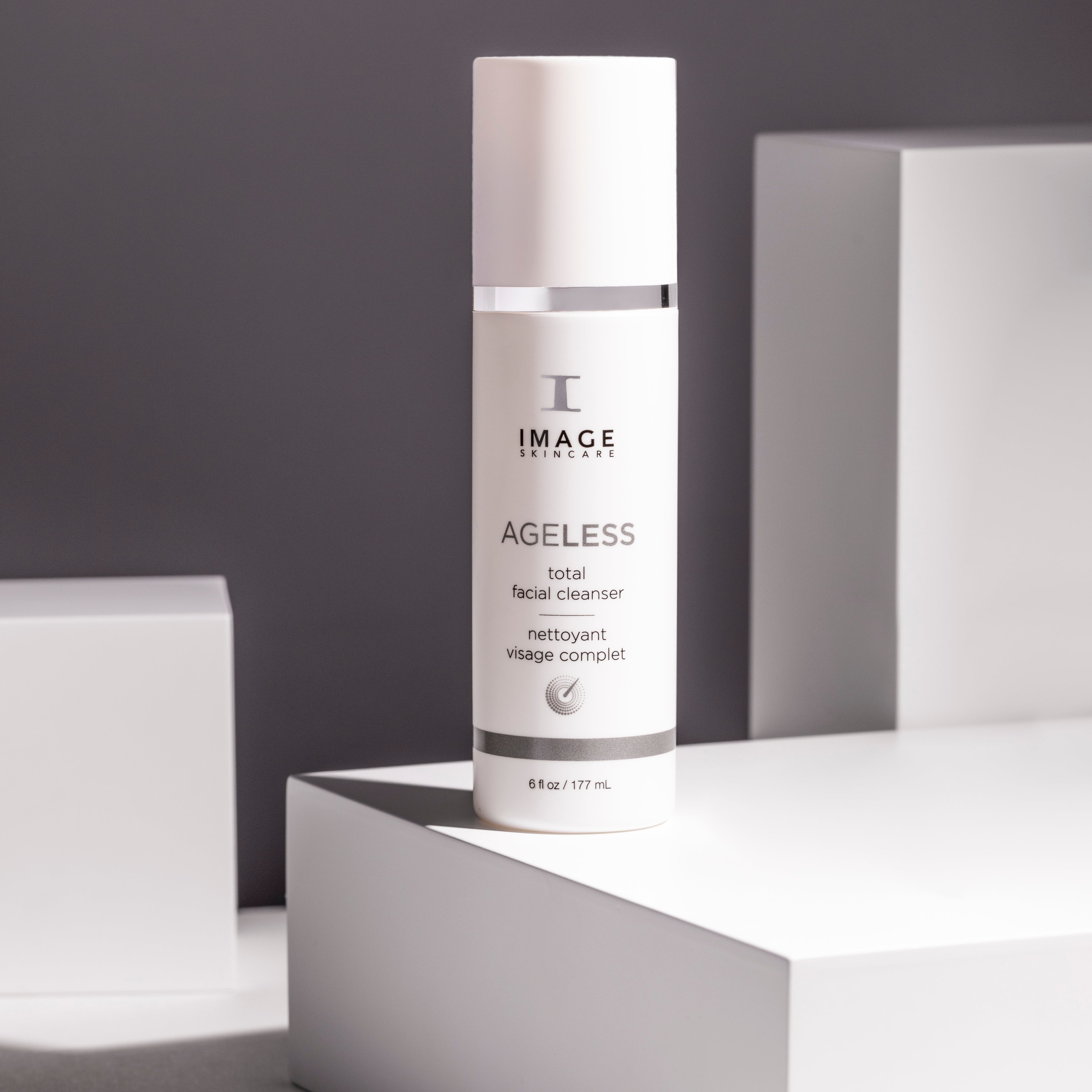 Skincare bottle labeled 'IMAGE Skincare' on a reflective surface with a gray background