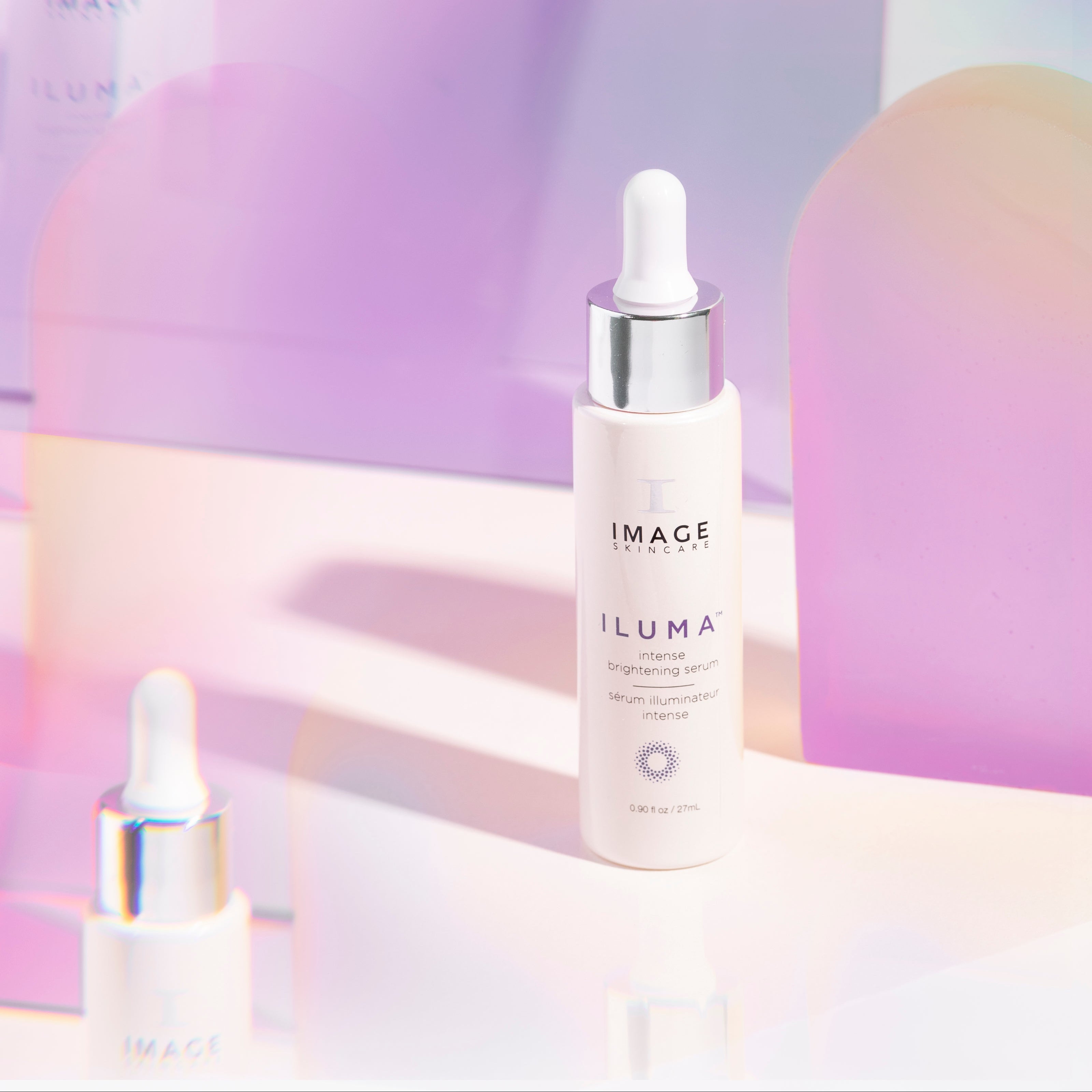 Image Skincare Iluma serum bottles with a pastel gradient background