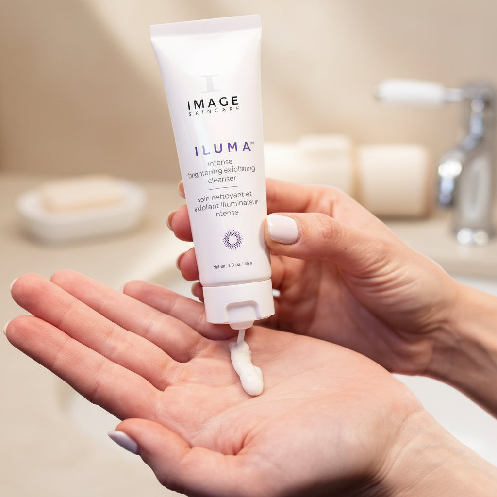 Hand holding a tube of Image Skincare Iluma cleanser with a small amount on the palm.