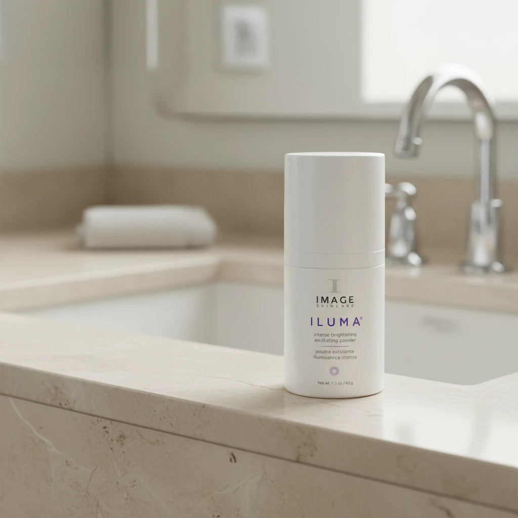 A white plastic container with a pump dispenser labeled ILUMA Intense Brightening Exfoliating Powder from IMAGE Skincare.