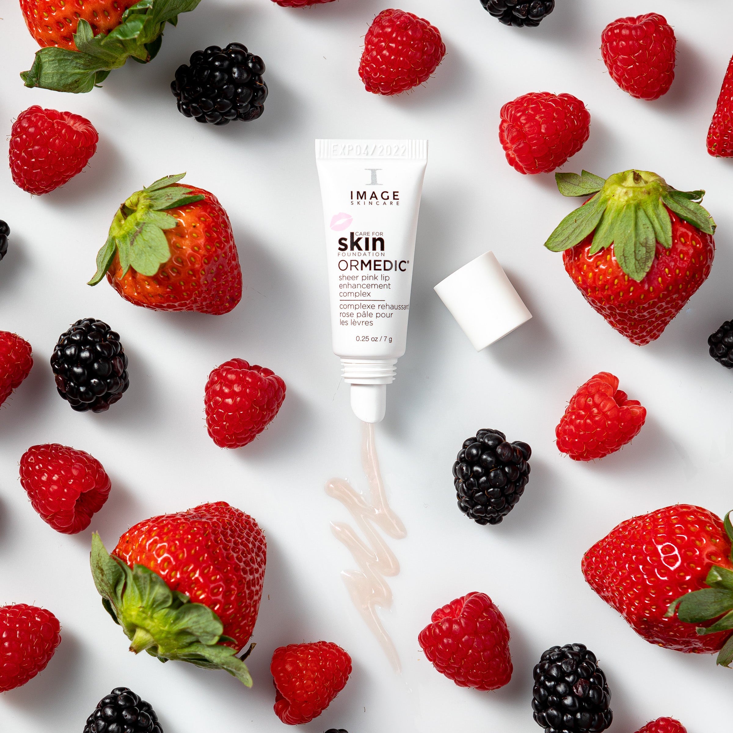 Skincare product with strawberries and raspberries on a white background