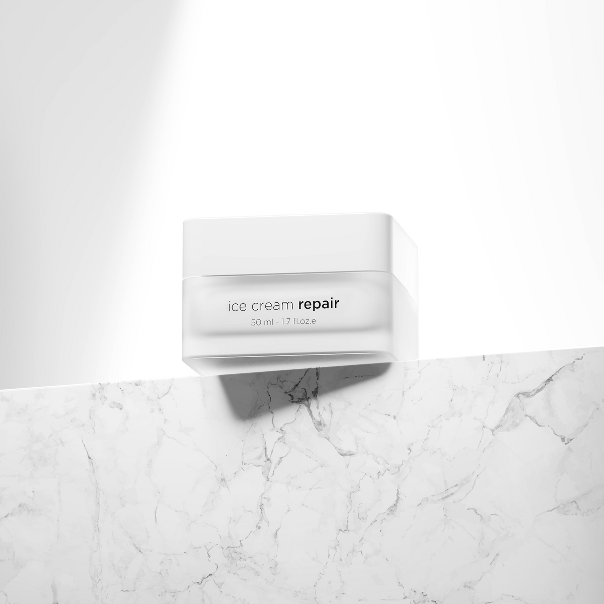 A white cosmetic jar labeled 'ice cream repair' sits on a white marble surface against a white background with a dramatic diagonal shadow.