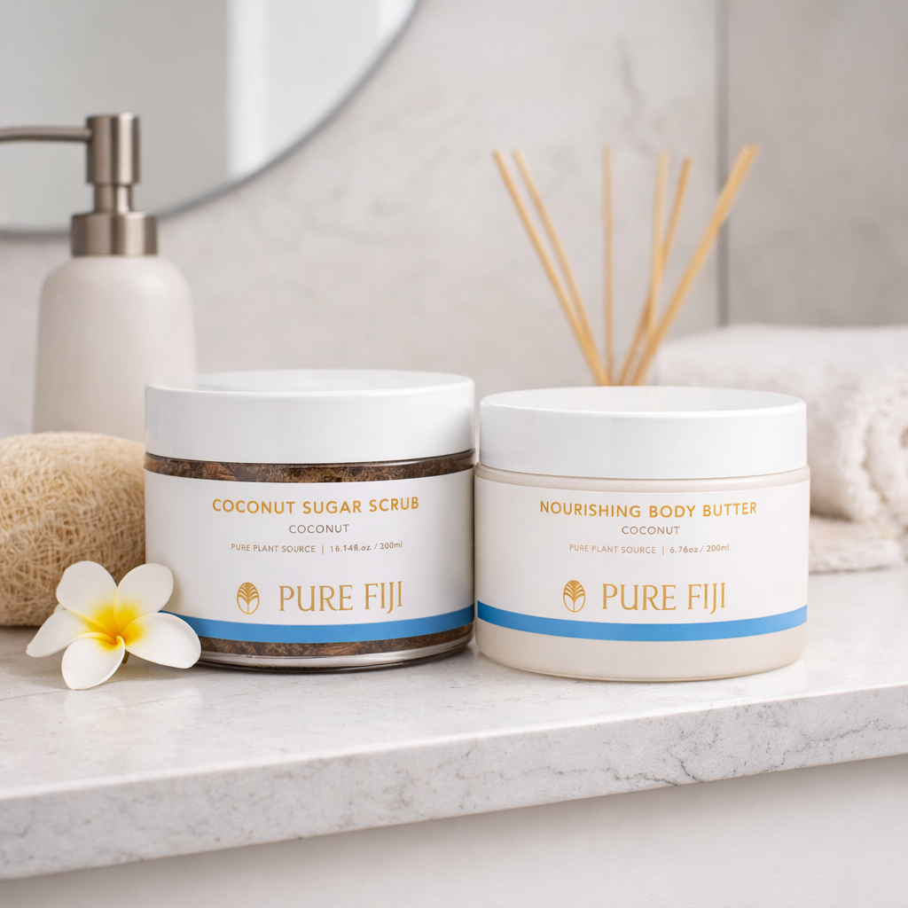 Two jars of Pure Fiji coconut products on a bathroom counter with a flower and soap.