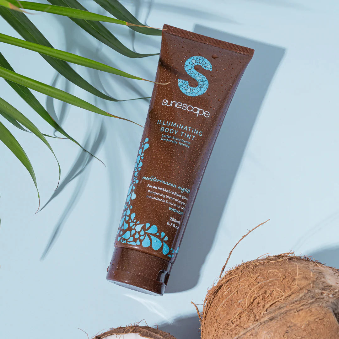 Sunescape illuminating body tint tube with coconut and leaves on a light blue background
