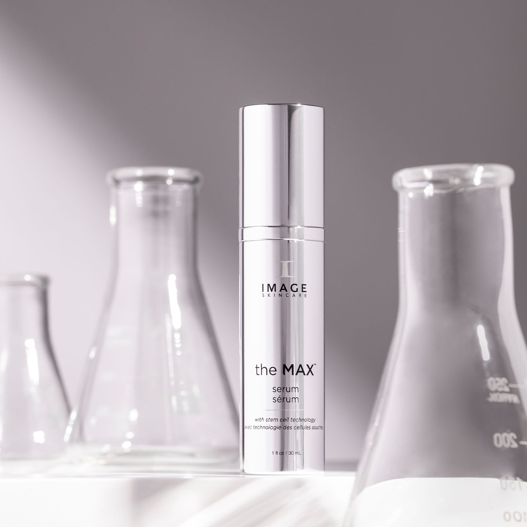 Skincare serum bottle labeled 'the MAX' with glass beakers in the background