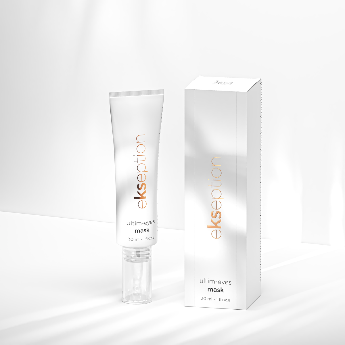 A white squeeze tube and matching white rectangular box for ekseption Ultim-Eyes Mask, featuring metallic silver gradients and orange brand lettering, set against a bright white background with soft shadows.