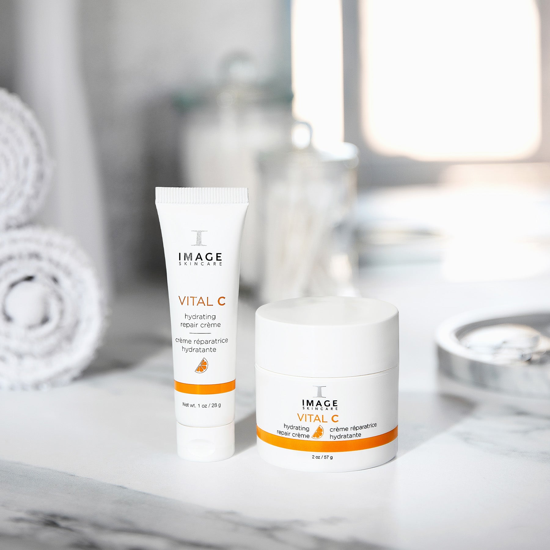 Two skincare products labeled 'Vital C' on a marble surface with blurred background