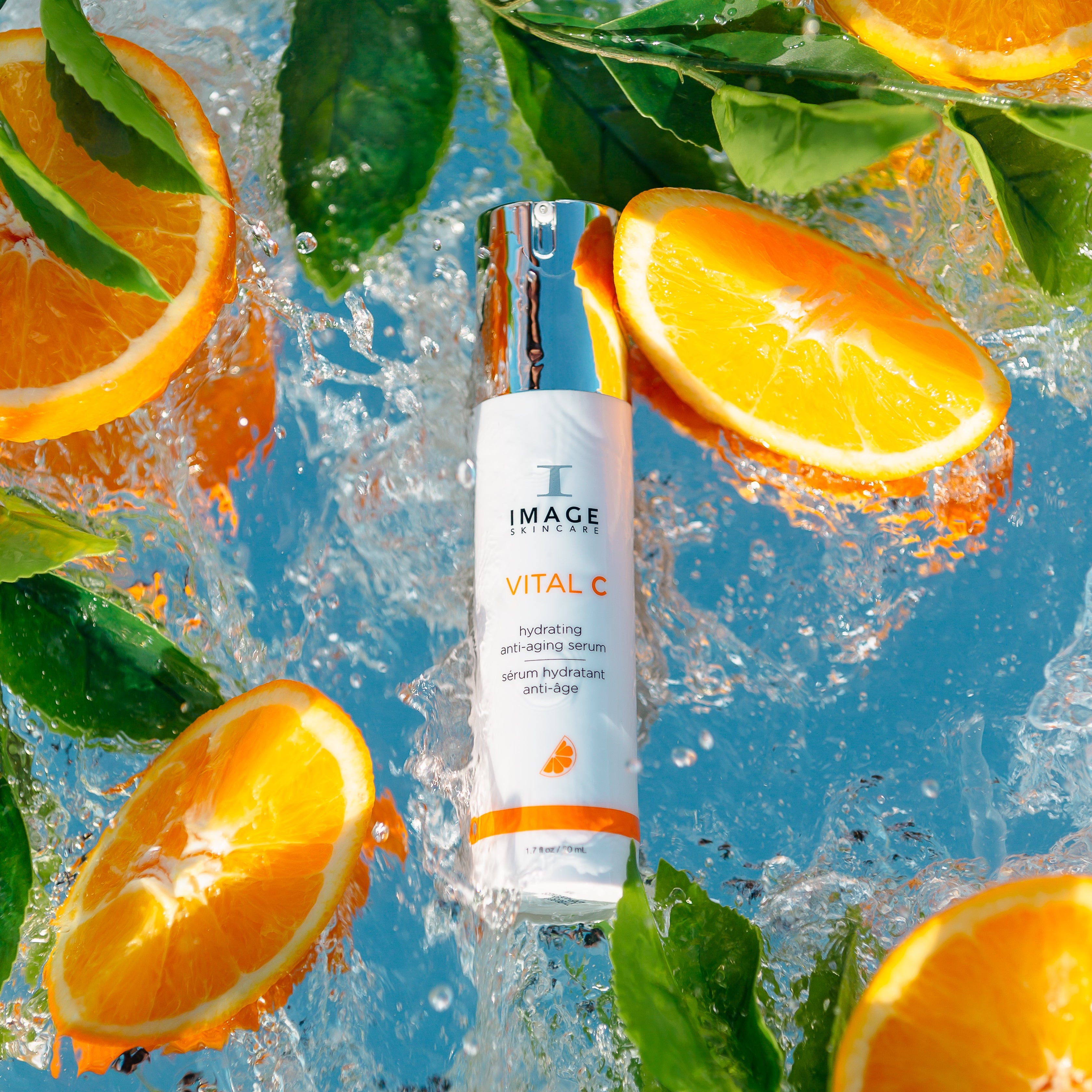 Skincare serum bottle with oranges and leaves on a blue background