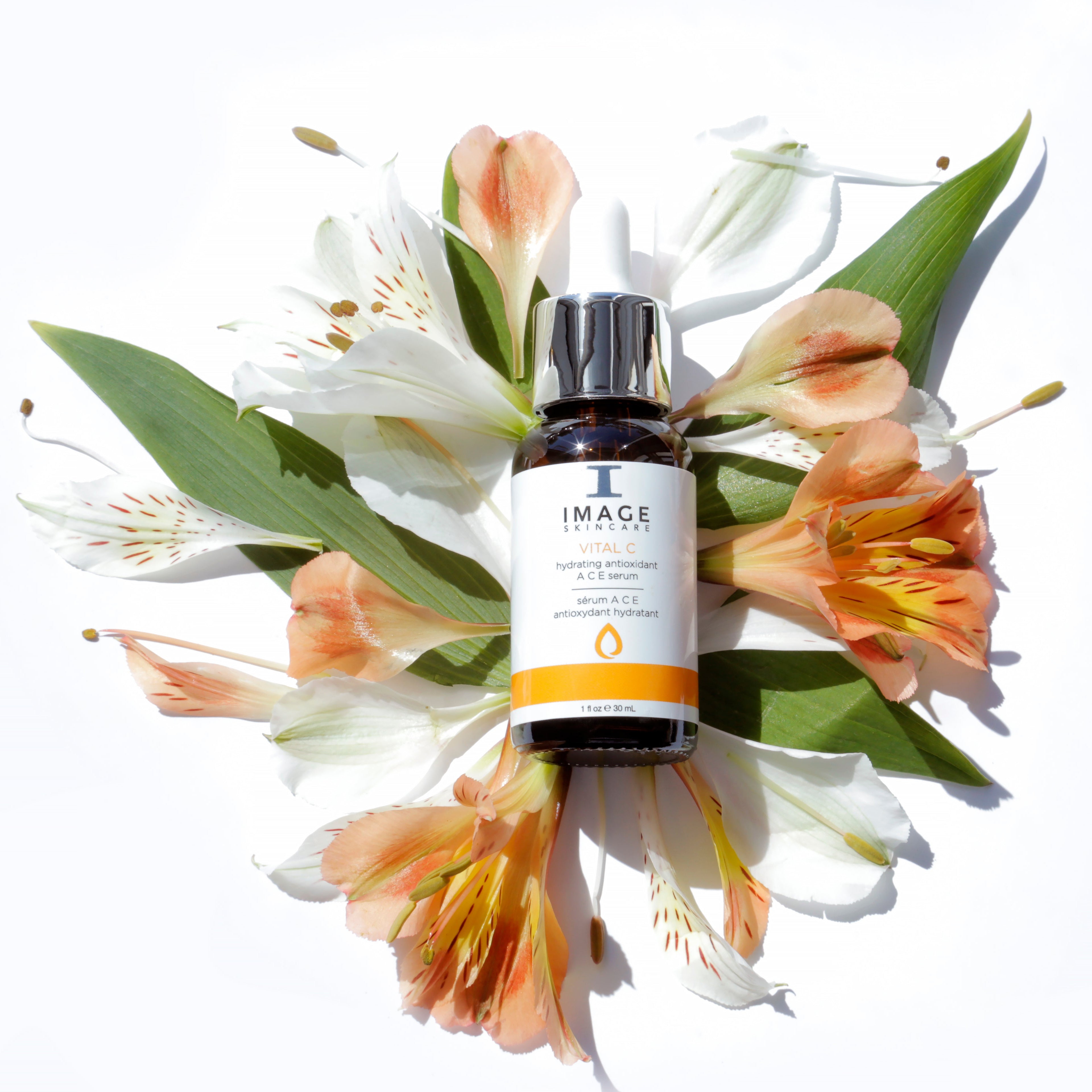 Bottle of Image Skincare product surrounded by flowers on a white background